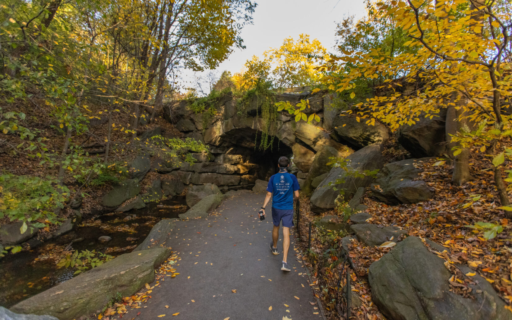 A hiker approaches the Huddlestone Arch in autumn