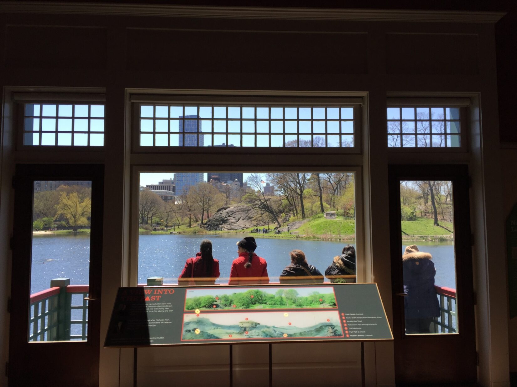 Part of the exhibit stands in front of a window, overlooking the landscape of the Harlem Meer it describes