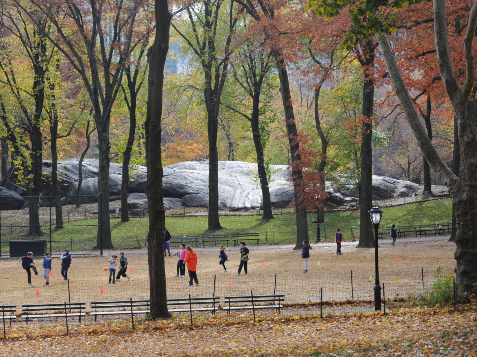 An autumn scene of a group of children playing at Heckscher Ballfield