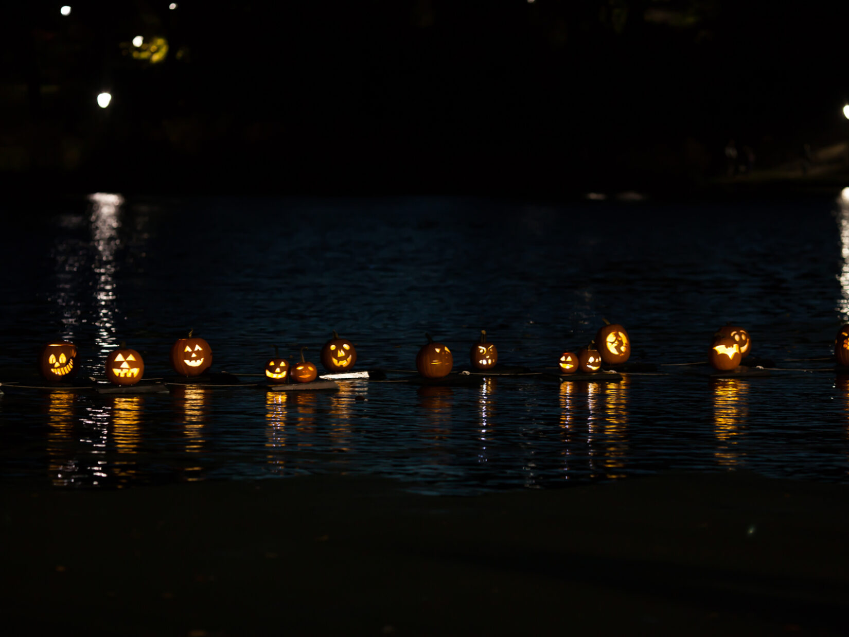 Pumpkins, lit from within, floating on the Meer at night