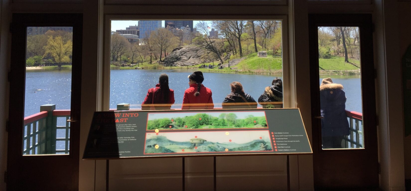 Part of the exhibit stands in front of a window, overlooking the landscape of the Harlem Meer it describes