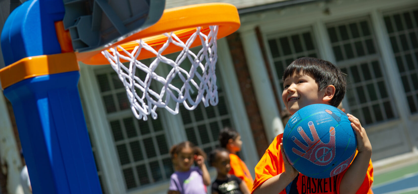 A young hoopster aiming for a toddler-appropriate basket