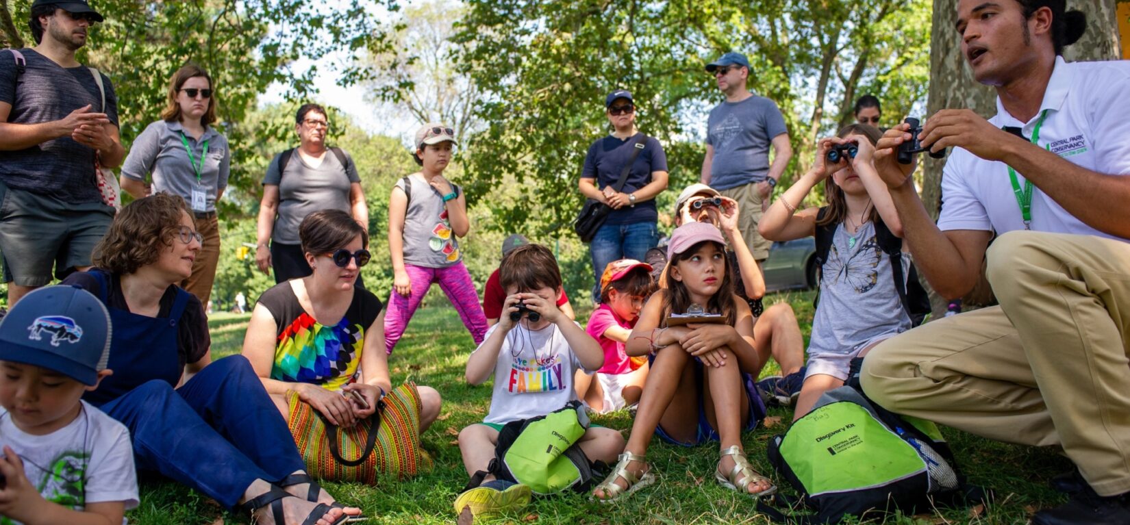 Various families gather around a Conservancy guide