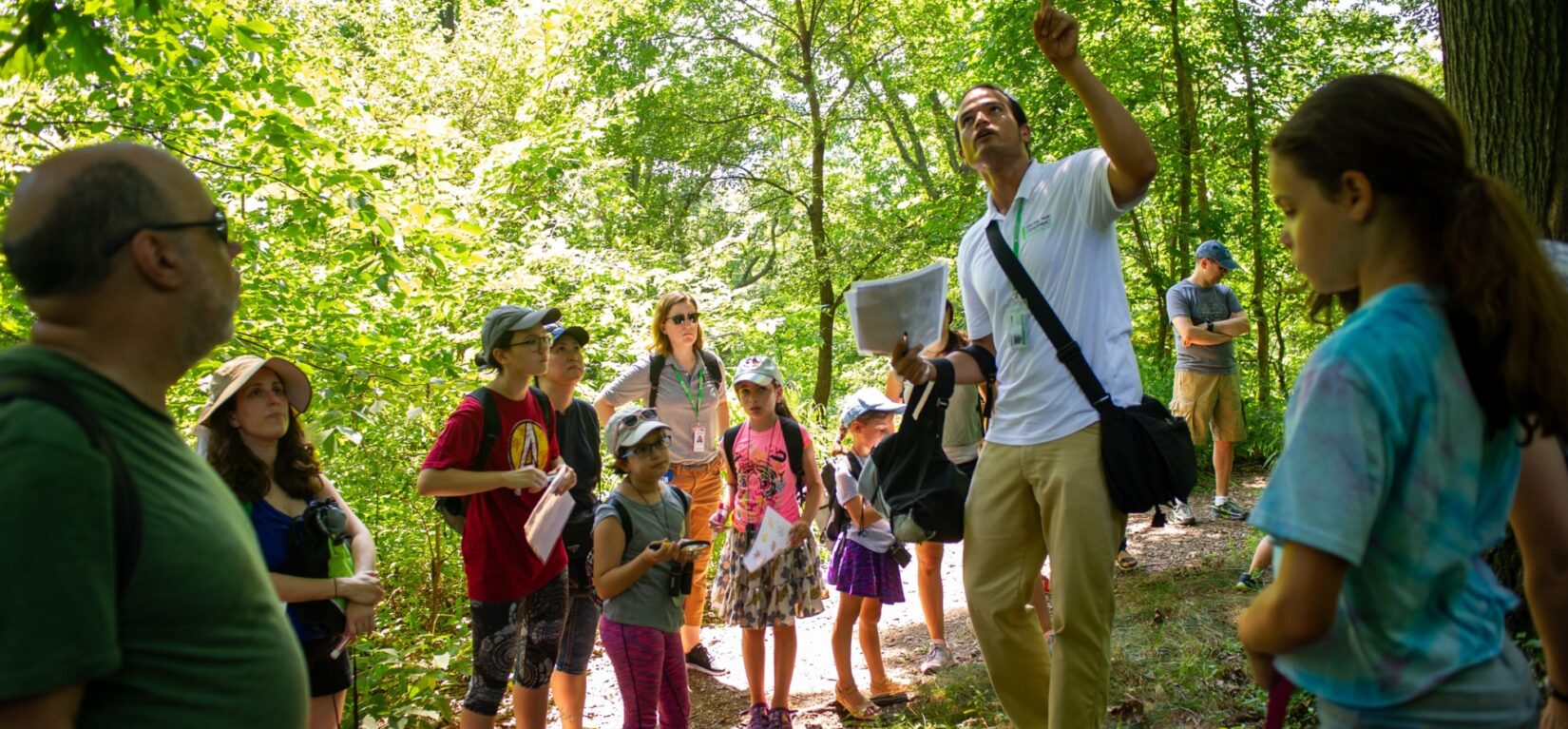 Kids and tour-goers in rapt attention to a tour guide in the North Woods