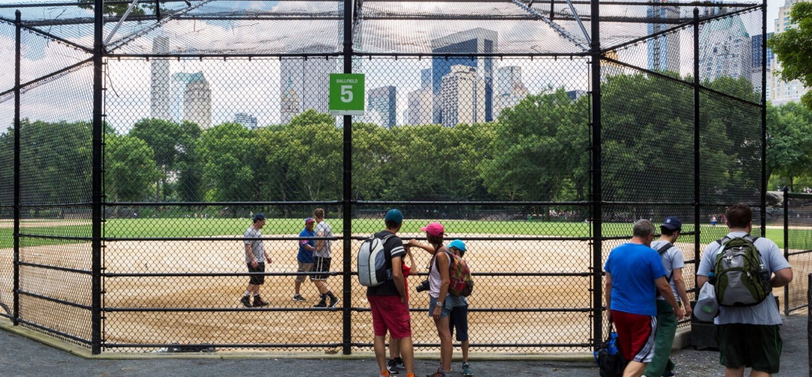 The midtown skyline seen through the chain-link backstop of ballfield #5