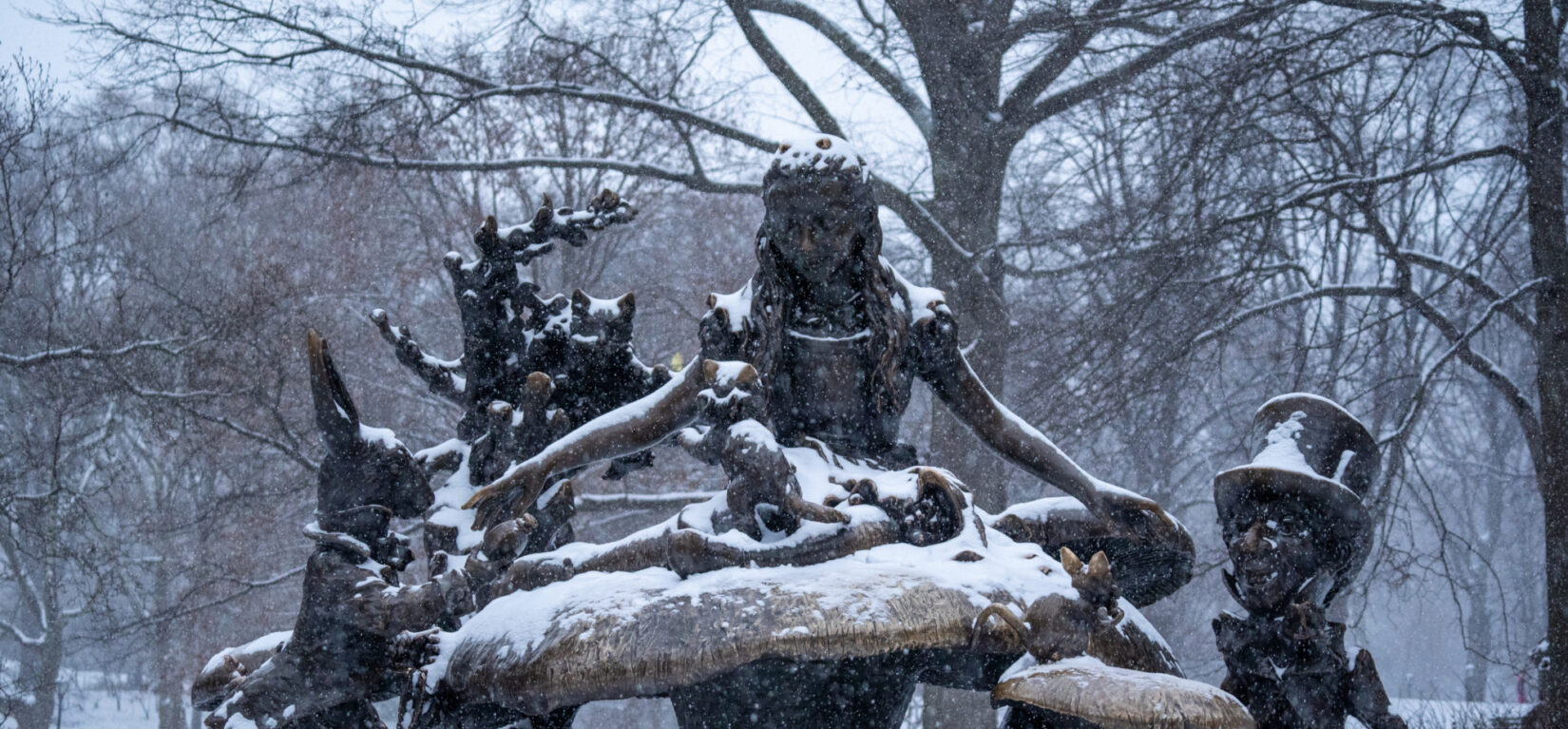 The Alice in Wonderland statue shown dusted with snow
