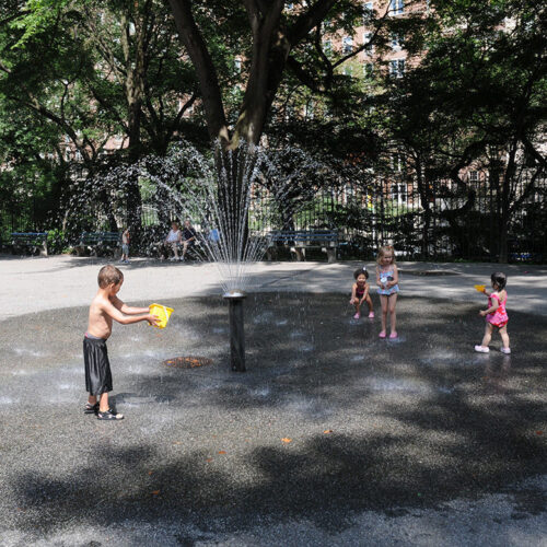 A boy plays at the water feature, before reconstruction