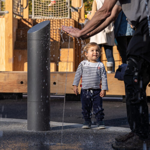 A toddler and parent at the water feature
