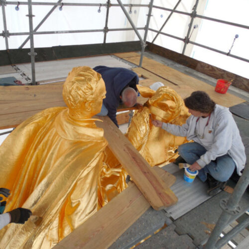 A worker on scaffolding restoring the Sherman statue